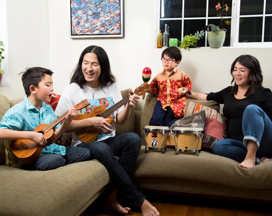 a group of people sitting on a couch playing guitars