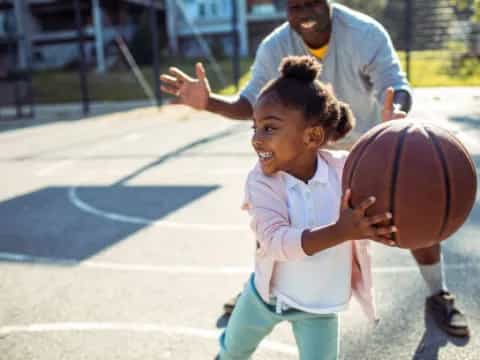 a young girl holding a basketball