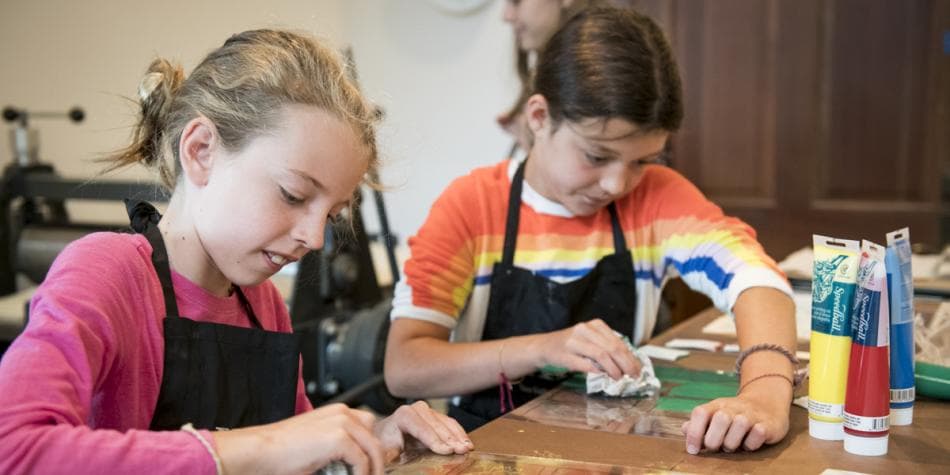 a woman and a girl looking at a tablet