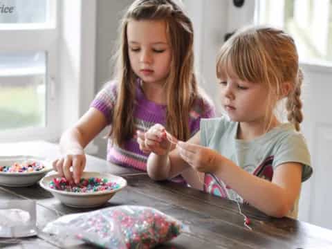 a couple of young girls eating cereal