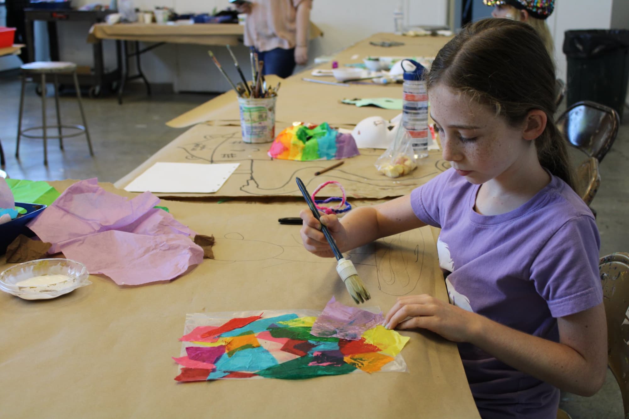 a young girl painting on a table