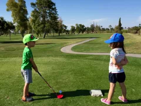 a couple of kids playing golf