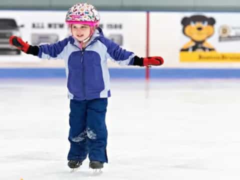 a child wearing a helmet and ice skating gear