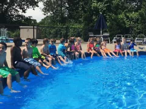 a group of people sitting around a pool