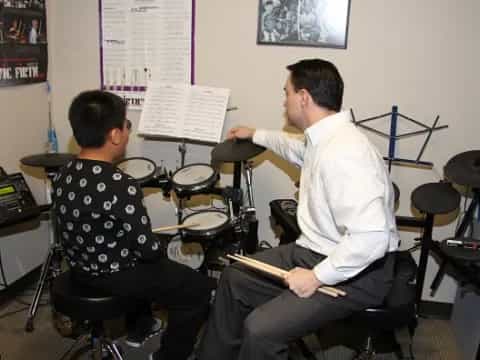 a man playing a musical instrument next to a man playing drums