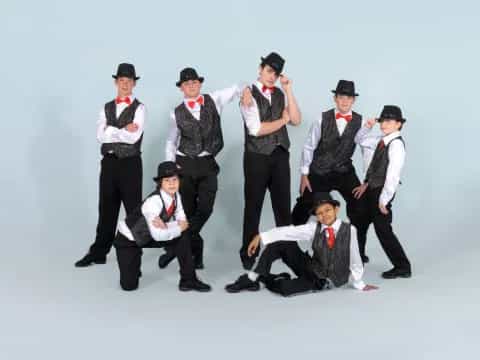 a group of men in black and white clothes posing for a photo