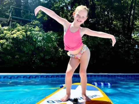 a girl jumping into a pool