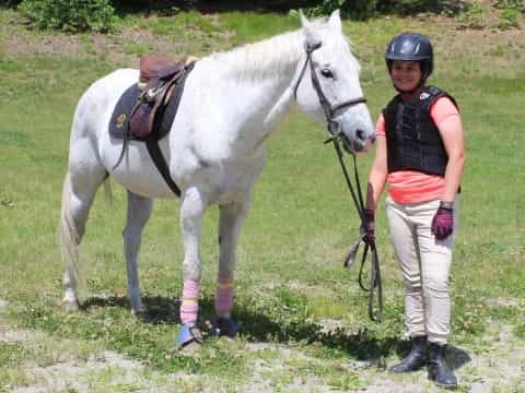 a person standing next to a white horse