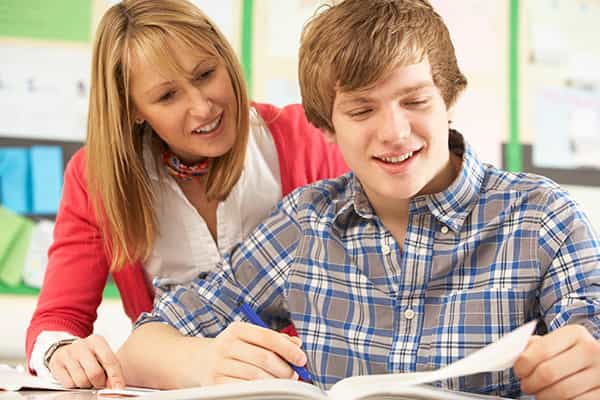 a boy and girl looking at a paper
