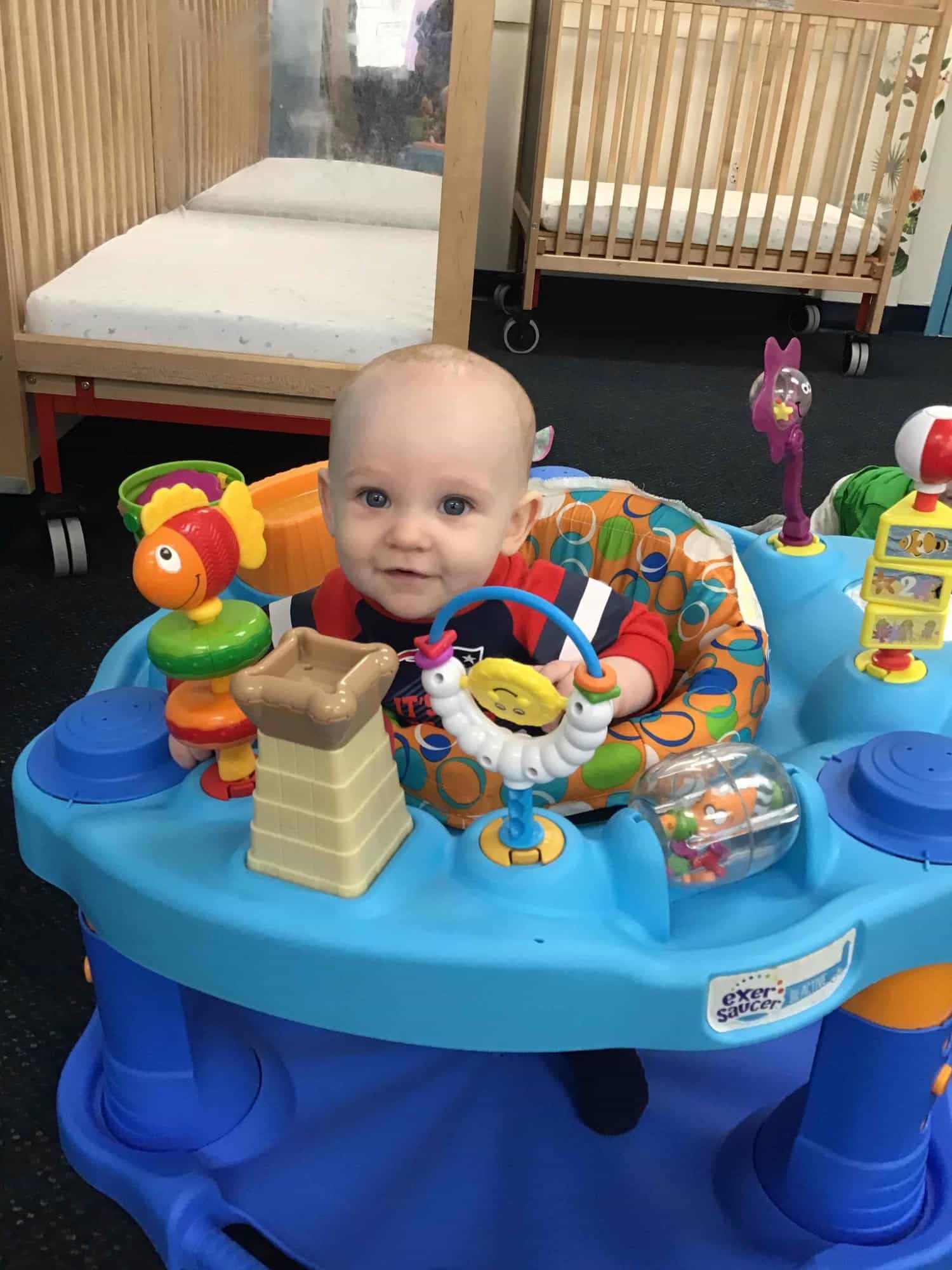 a baby sitting at a table with toys on it