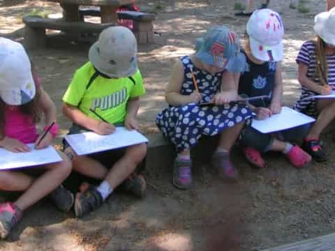 a group of children sitting on the ground reading books