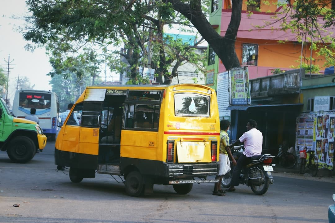 a man on a motorcycle next to a yellow bus