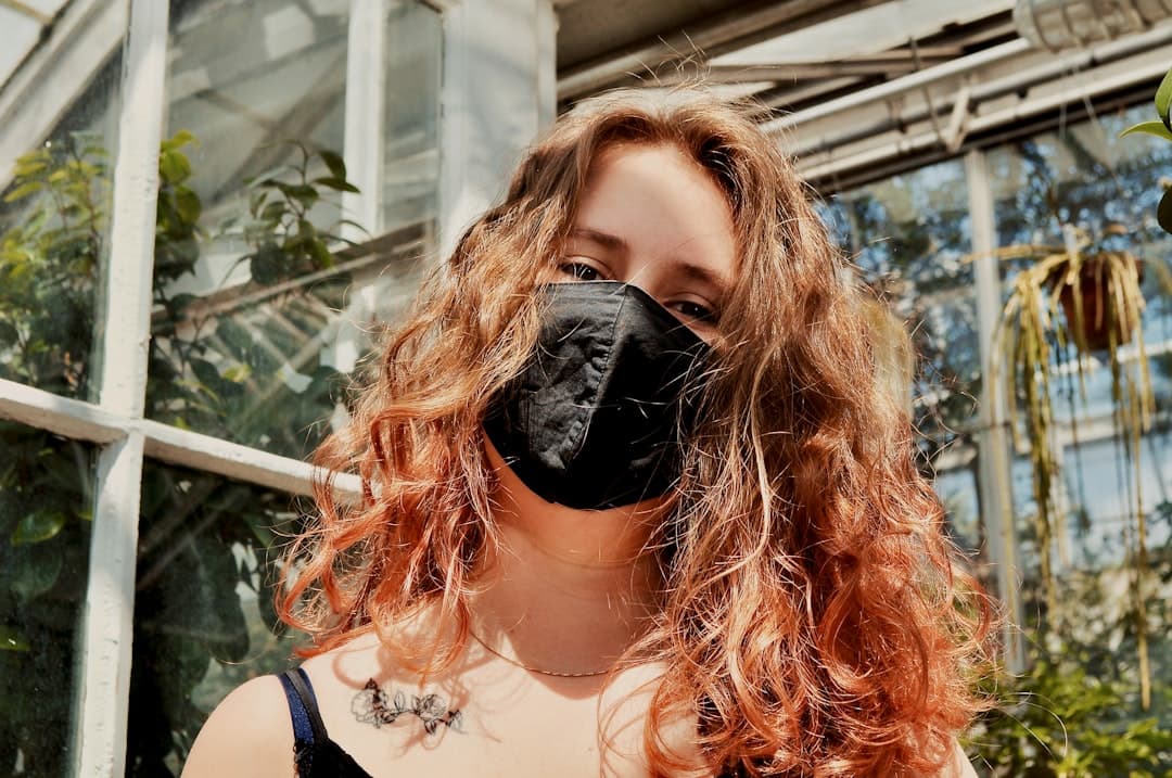 a woman with red hair wearing a black mask