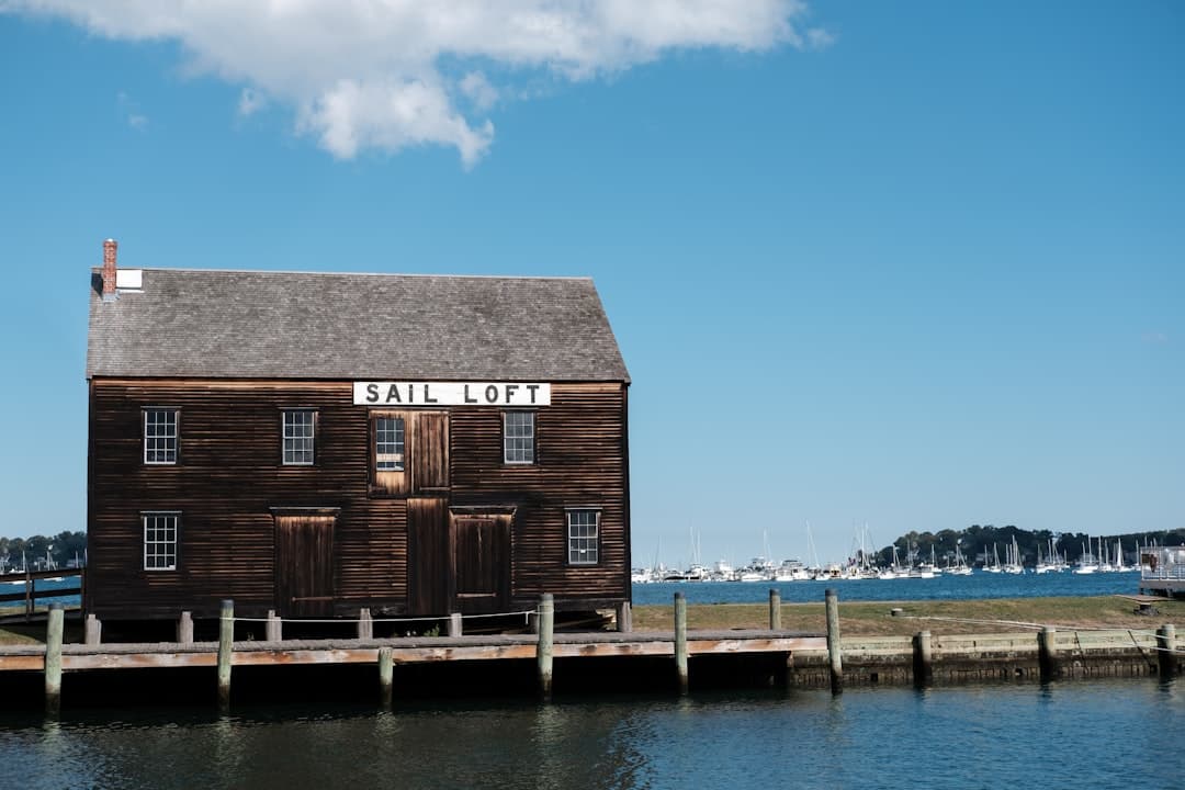 a wooden building sitting on top of a pier next to a body of water