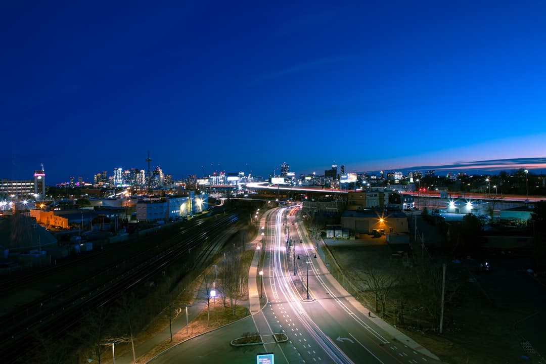 a city street at night with a train on the tracks